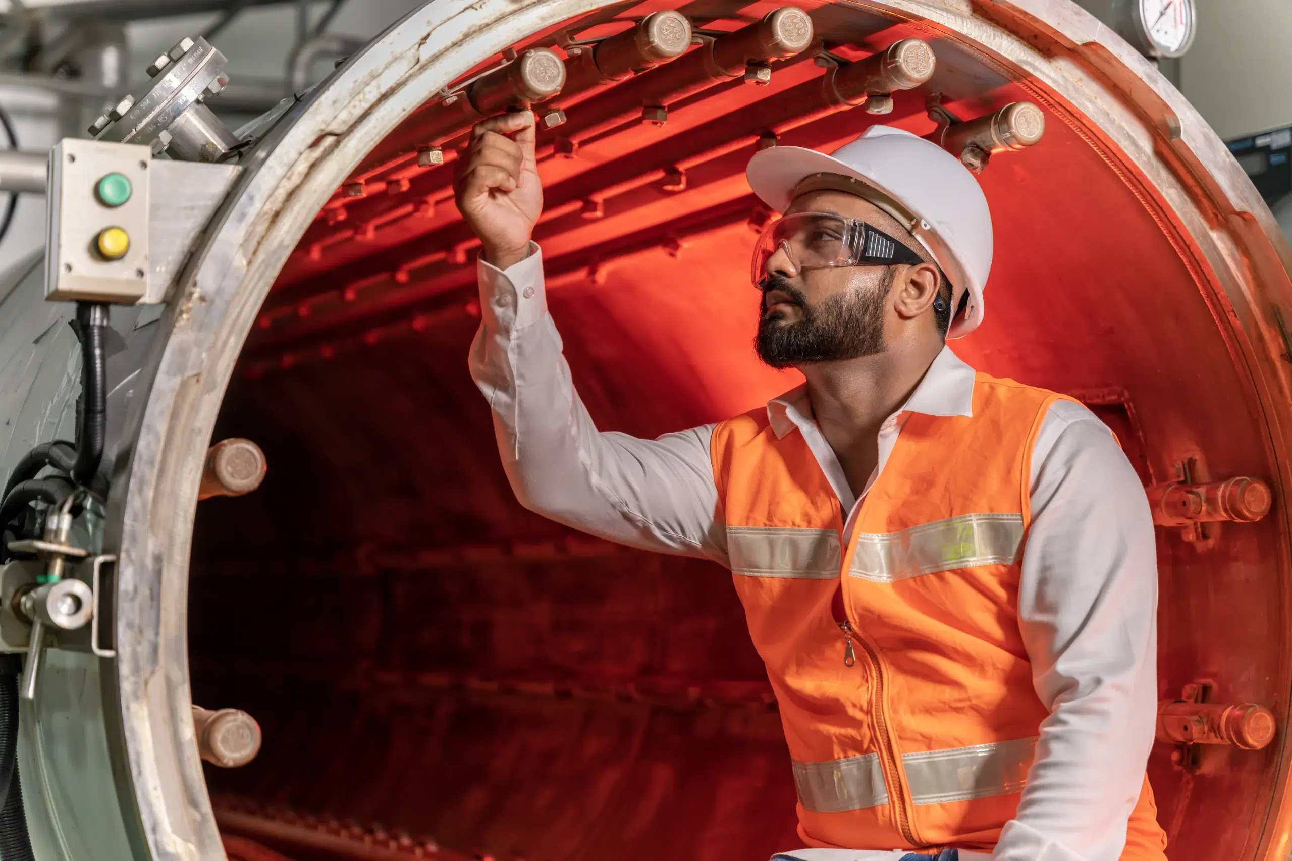 Ingénieur inspectant l'intérieur d'un équipement industriel en installation nucléaire de base
