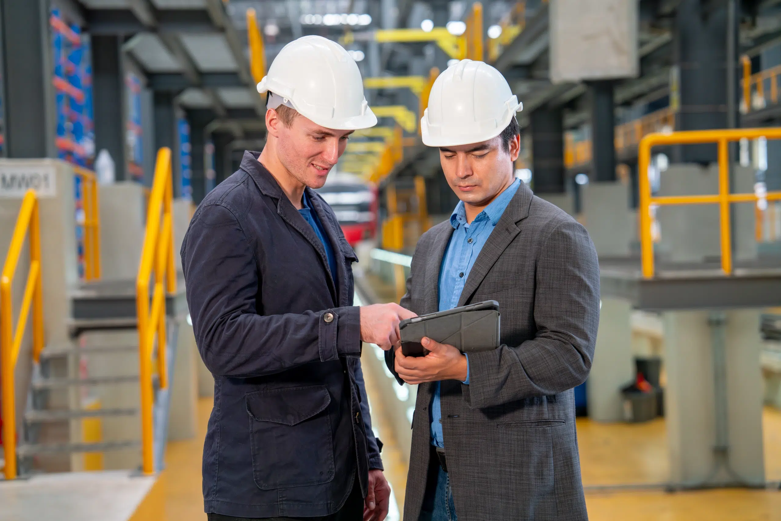 Deux professionnels examinant des données sur une tablette dans un environnement industriel
